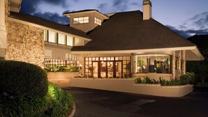 A modern two-story house with a stone facade, large windows, and a well-lit entrance. - Hilton Garden Inn Monterey (Monterey)
