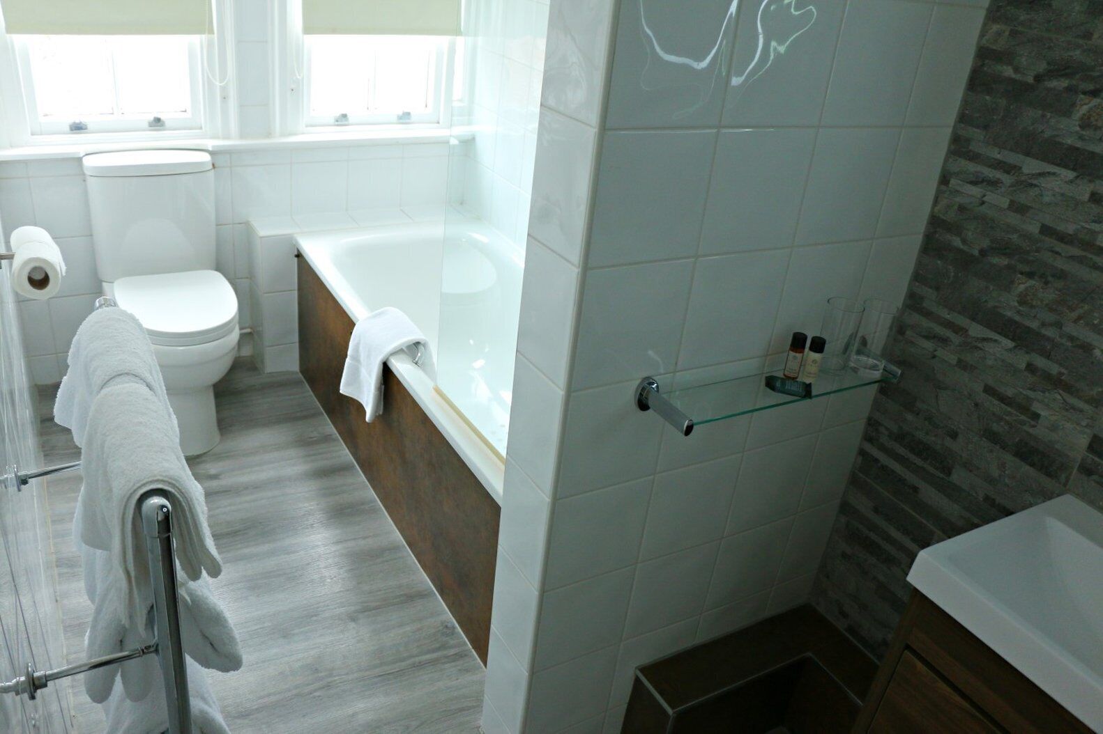 A modern bathroom with a toilet, bathtub, and shower area.