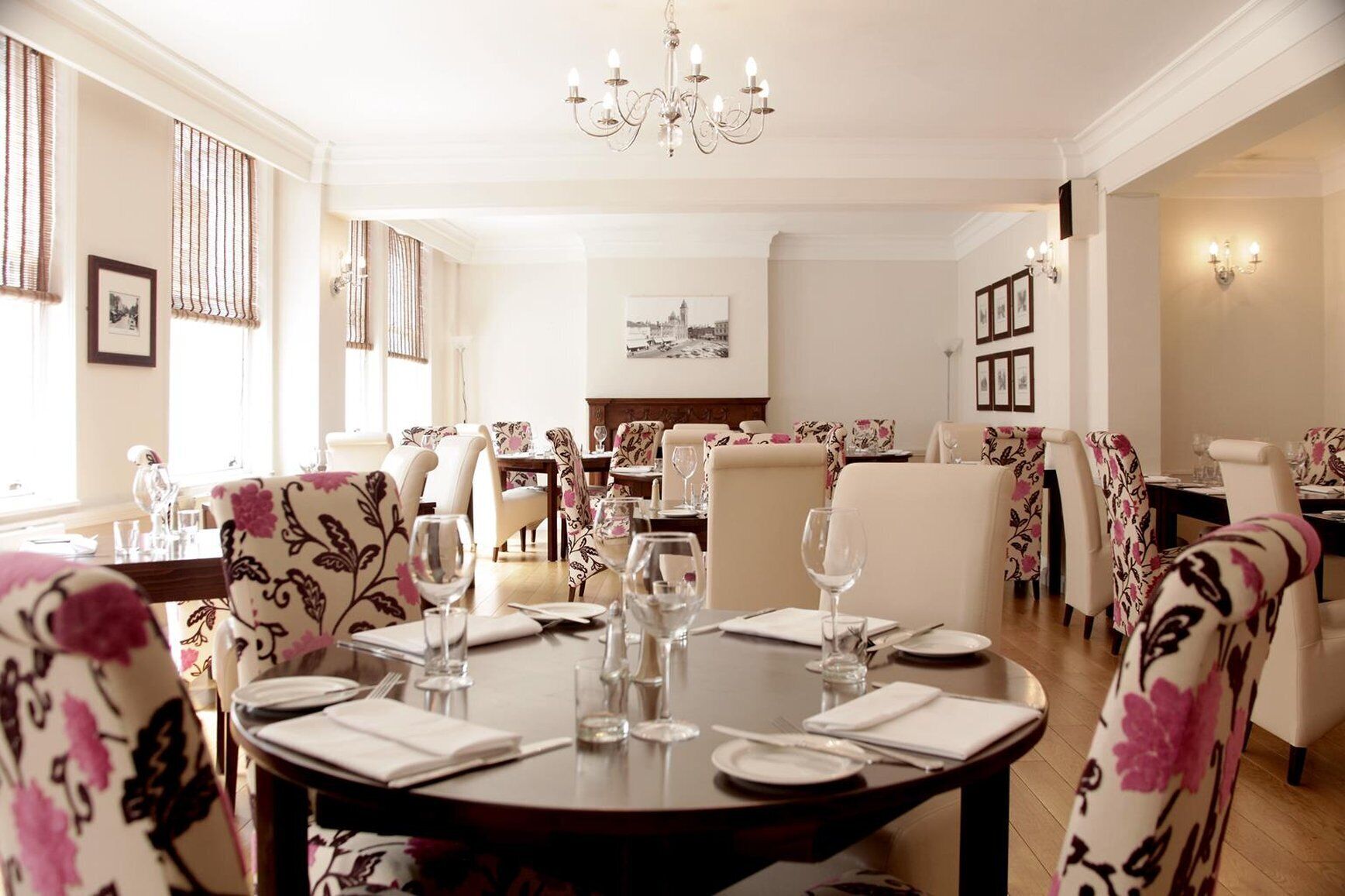 Un espace repas avec des tables rondes disposées pour accueillir quatre personnes, entourées de chaises ornées de motifs floraux.