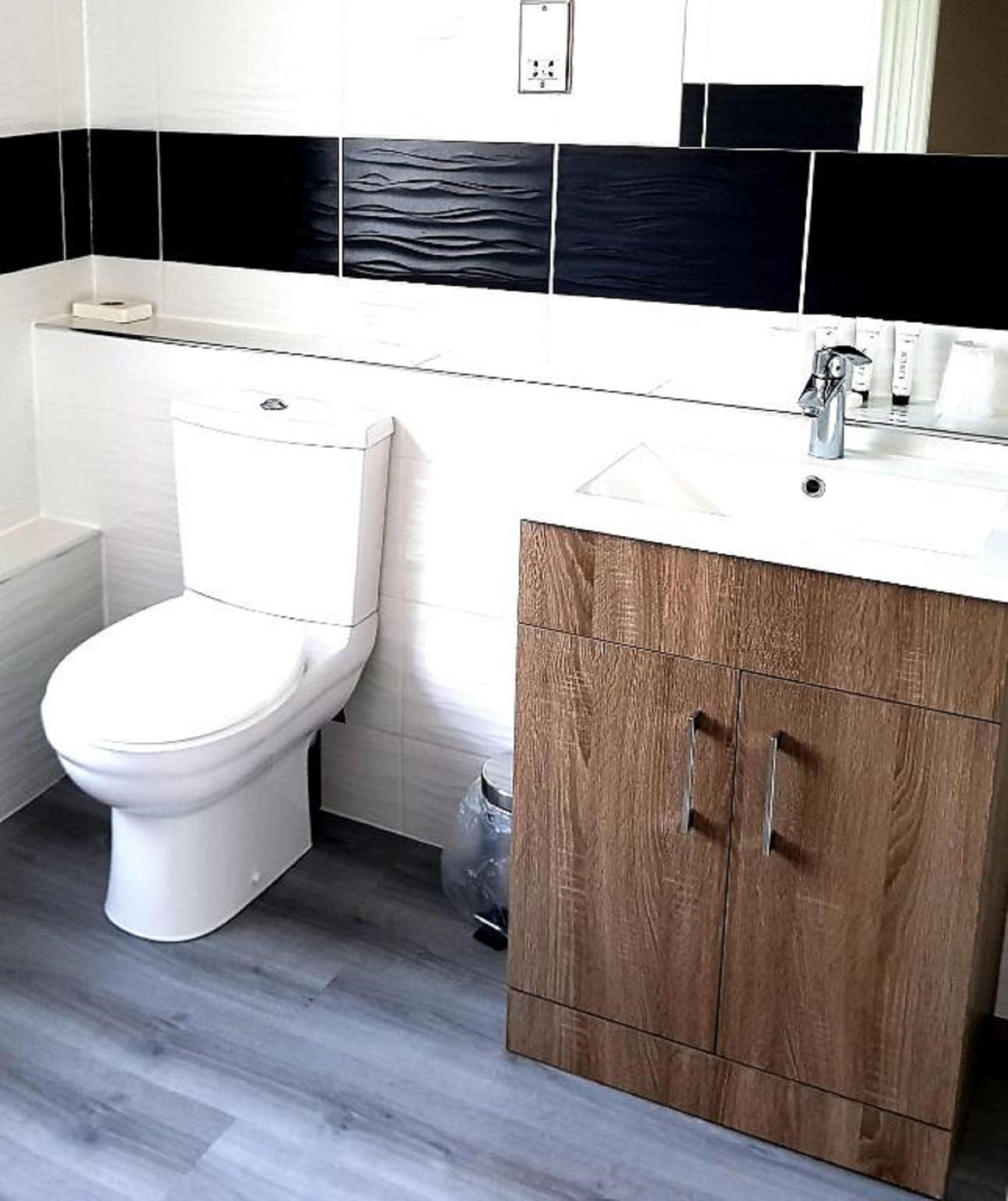 Une salle de bain avec des toilettes, un lavabo et un meuble de rangement.
