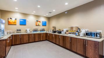 A modern kitchen with wooden cabinets, a granite countertop, and various appliances like a coffee maker, microwave, and toaster.