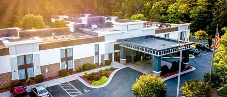 A modern hotel with a flat roof, a covered entrance, and a parking lot with handicapped spaces.