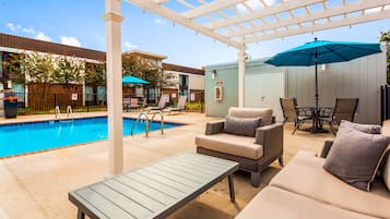 Una piscina al aire libre de temporada, sillones reclinables de piscina