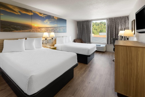 Camas con pillow-top, escritorio y cortinas blackout