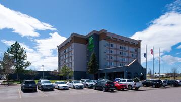 Un hotel Holiday Inn con un estacionamiento lleno de coches.