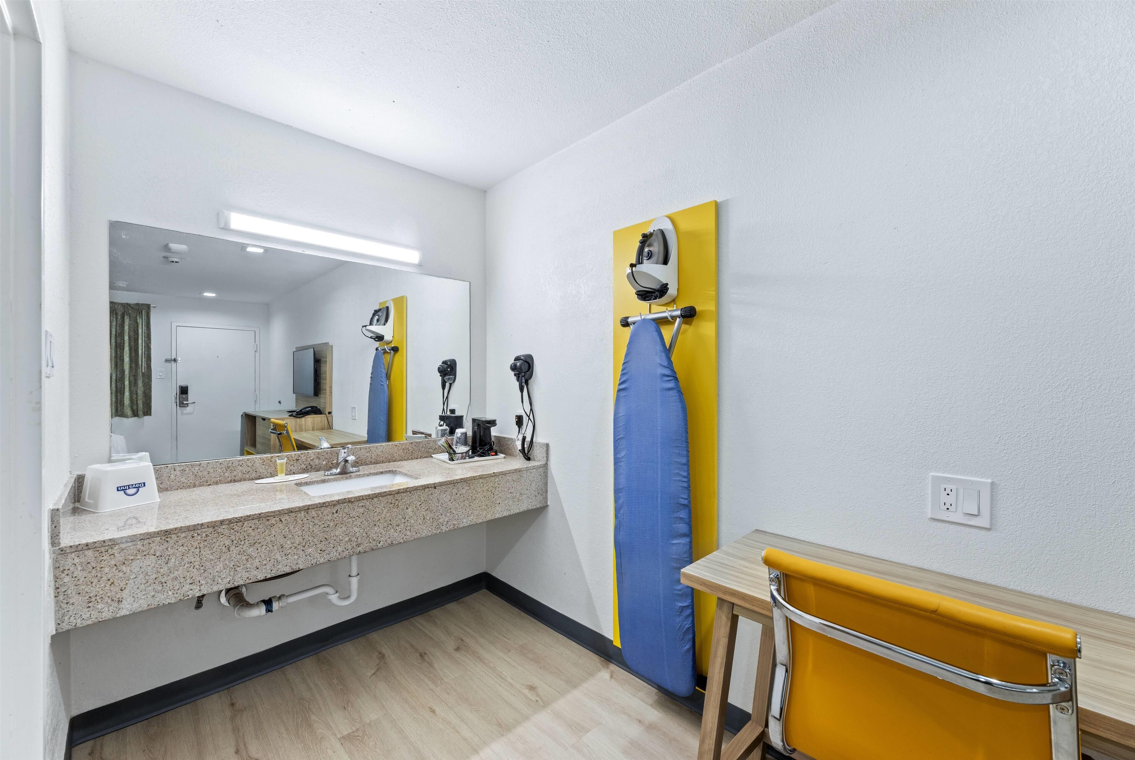 A bathroom with a sink, mirror, and towel rack.