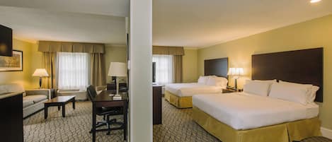 A hotel room with two beds, a desk, a chair, and a television.
