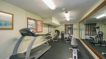 A gym with treadmills, weight machines, and exercise balls.