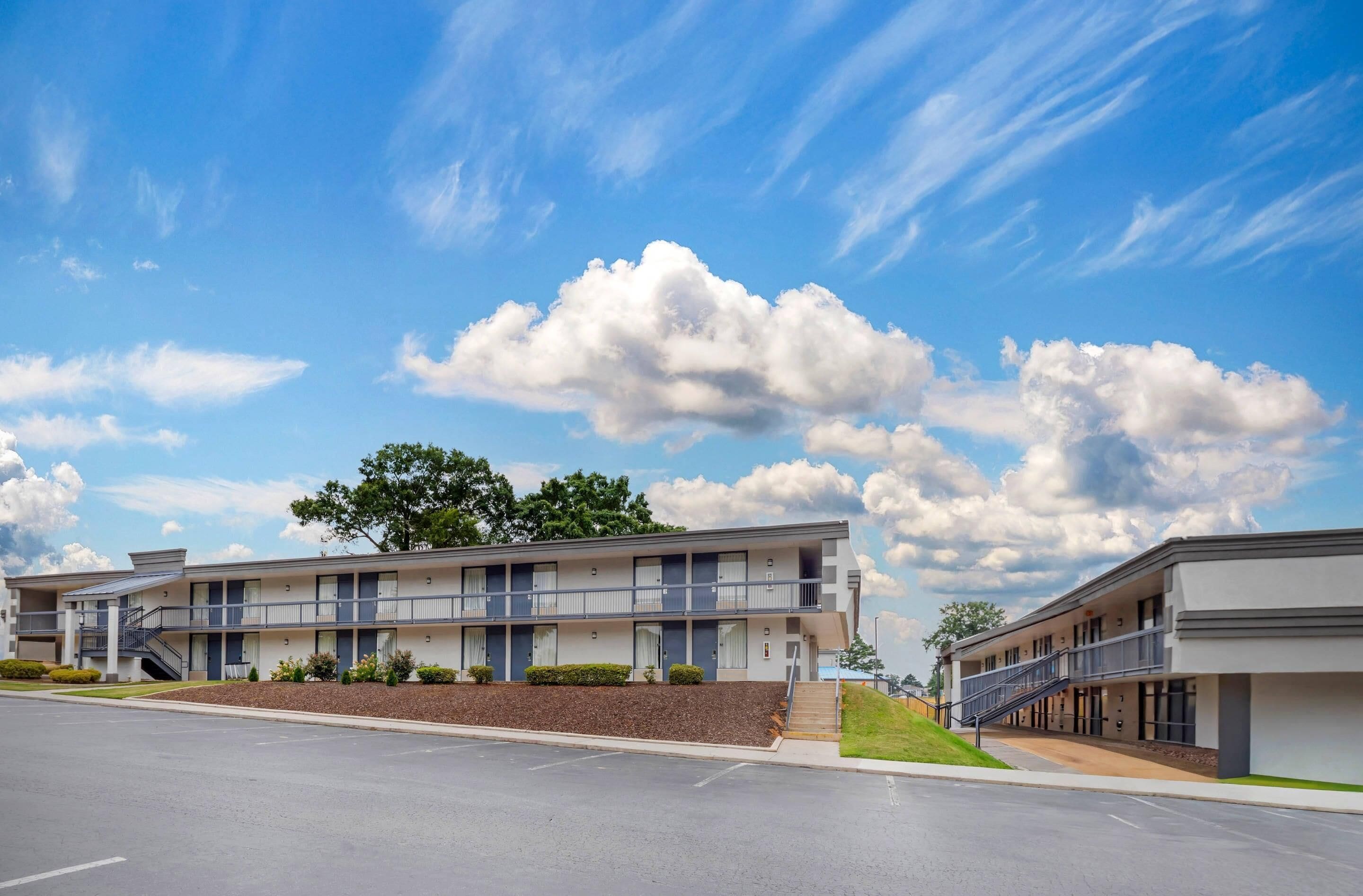 Un motel moderne, composé d’un bâtiment à deux étages, d’un passage couvert et d’un jardin paysager à l’avant.