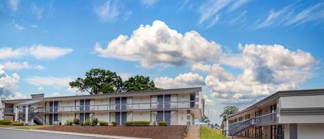 Un motel moderne, composé d’un bâtiment à deux étages, d’un passage couvert et d’un jardin paysager à l’avant.