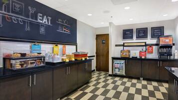 A breakfast area with a chalkboard wall, a coffee machine, and a refrigerator.