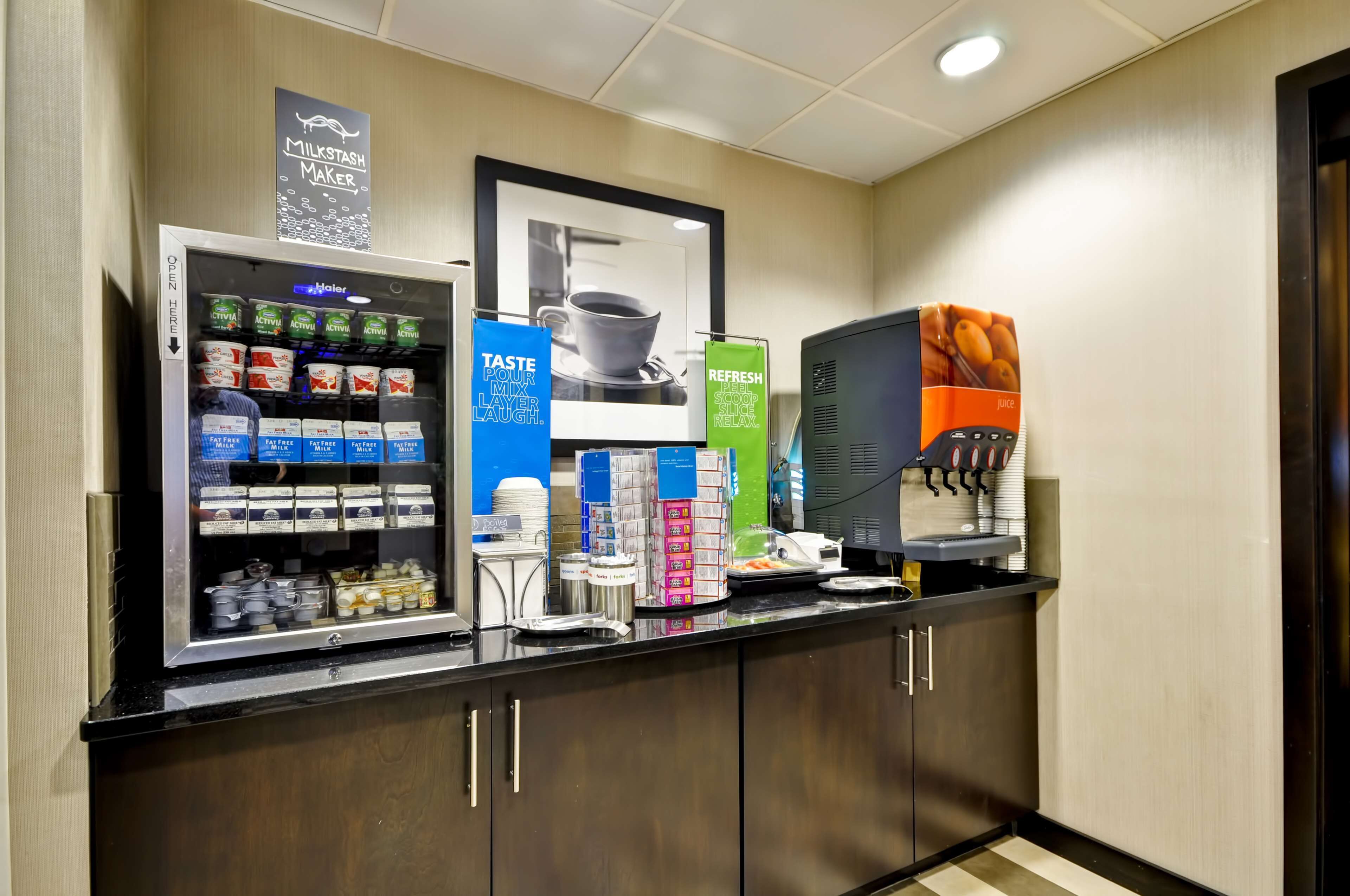 A self-service beverage station with various drink options and a milkshaker.