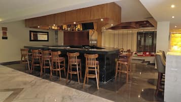 Een moderne keuken met een centraal eiland, barkrukken en een eethoek met een tafel en stoelen.