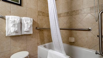 Un bagno con vasca, doccia e WC. Due asciugamani sono appesi a un porta-asciugamani.