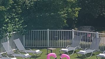 Una piscina al aire libre, tumbonas