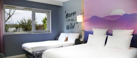 A hotel room with two beds, a window, a wall mural, and a clock on a bedside table.