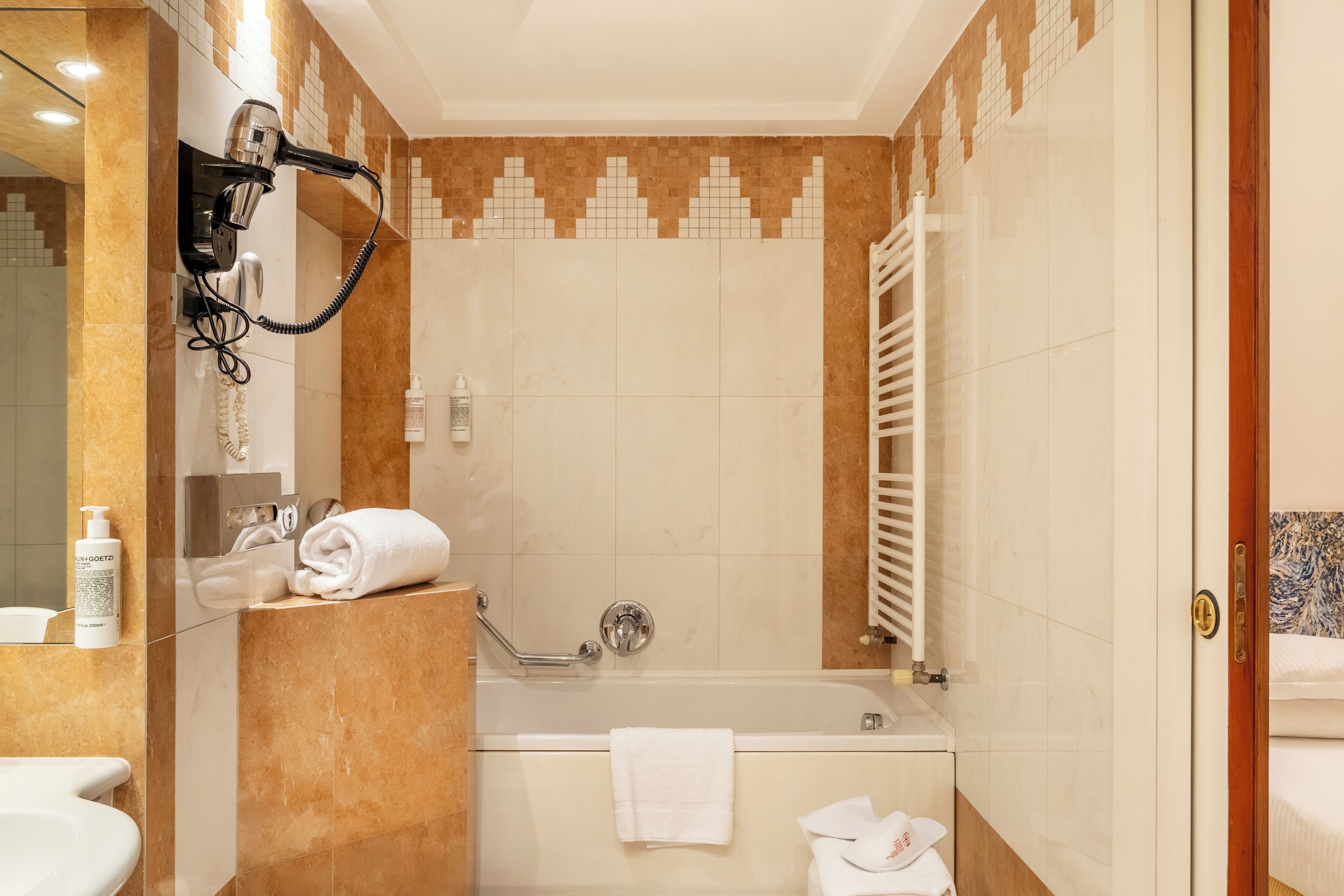 Een moderne badkamer met een ingebouwde haardroger, een badkuip en een douche.