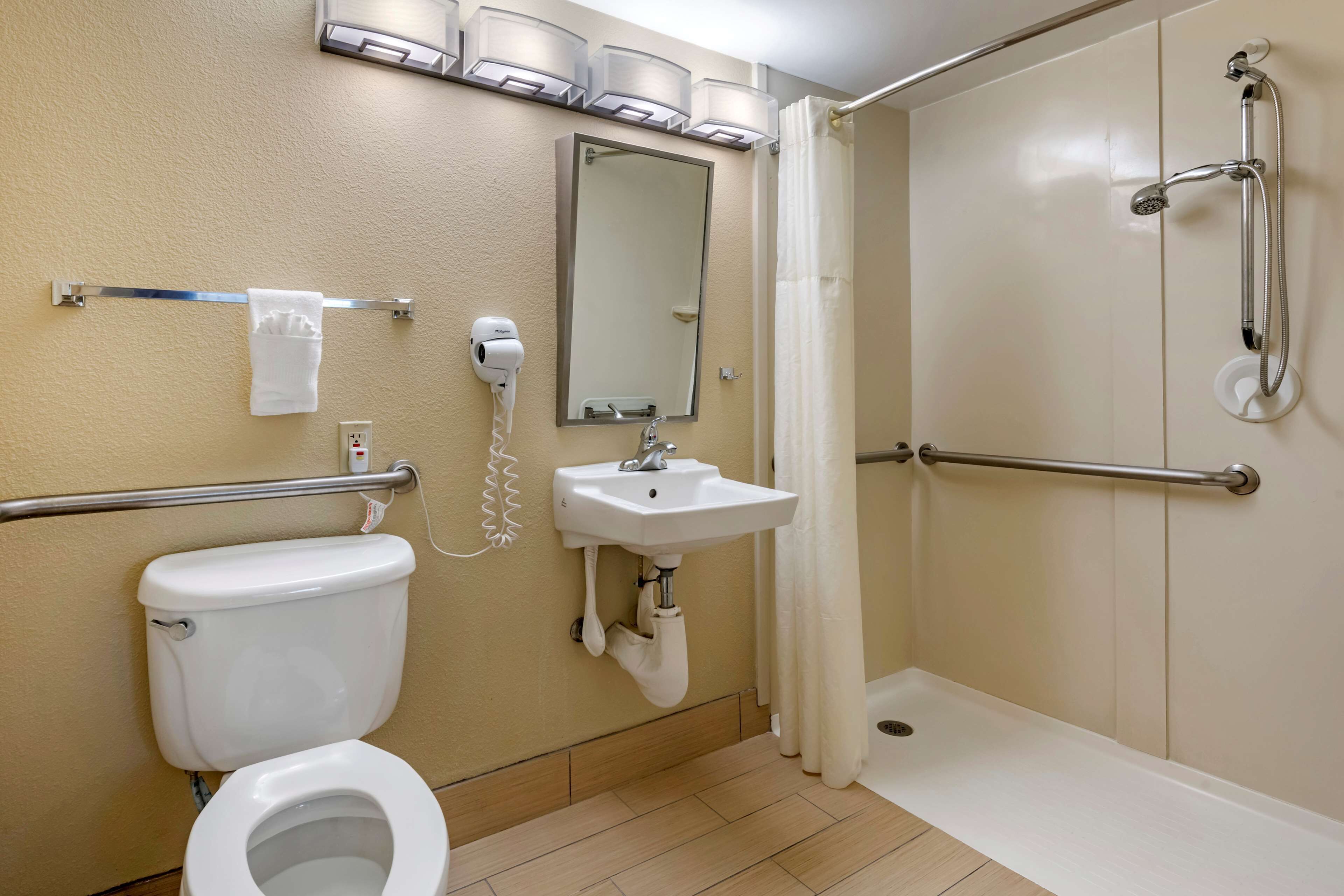 A bathroom with a toilet, sink, and shower.
