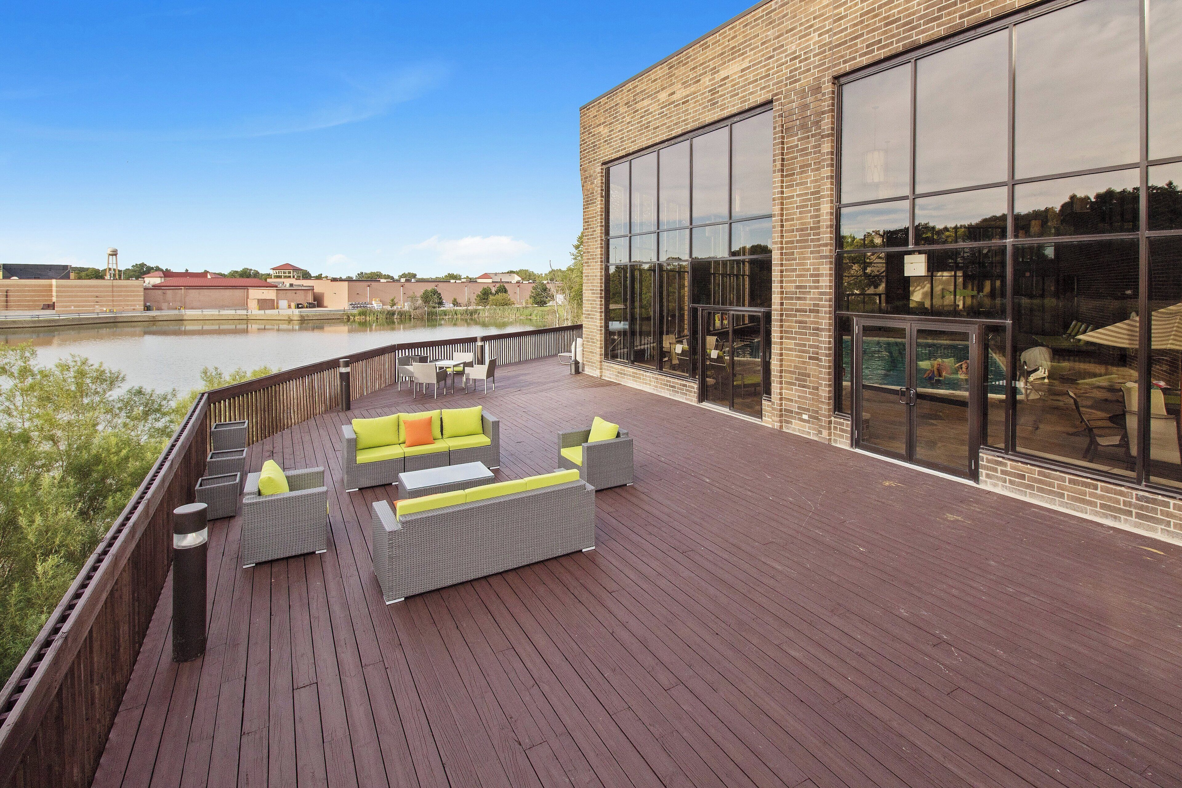 Una terraza con mobiliario exterior y vistas a un cuerpo de agua.
