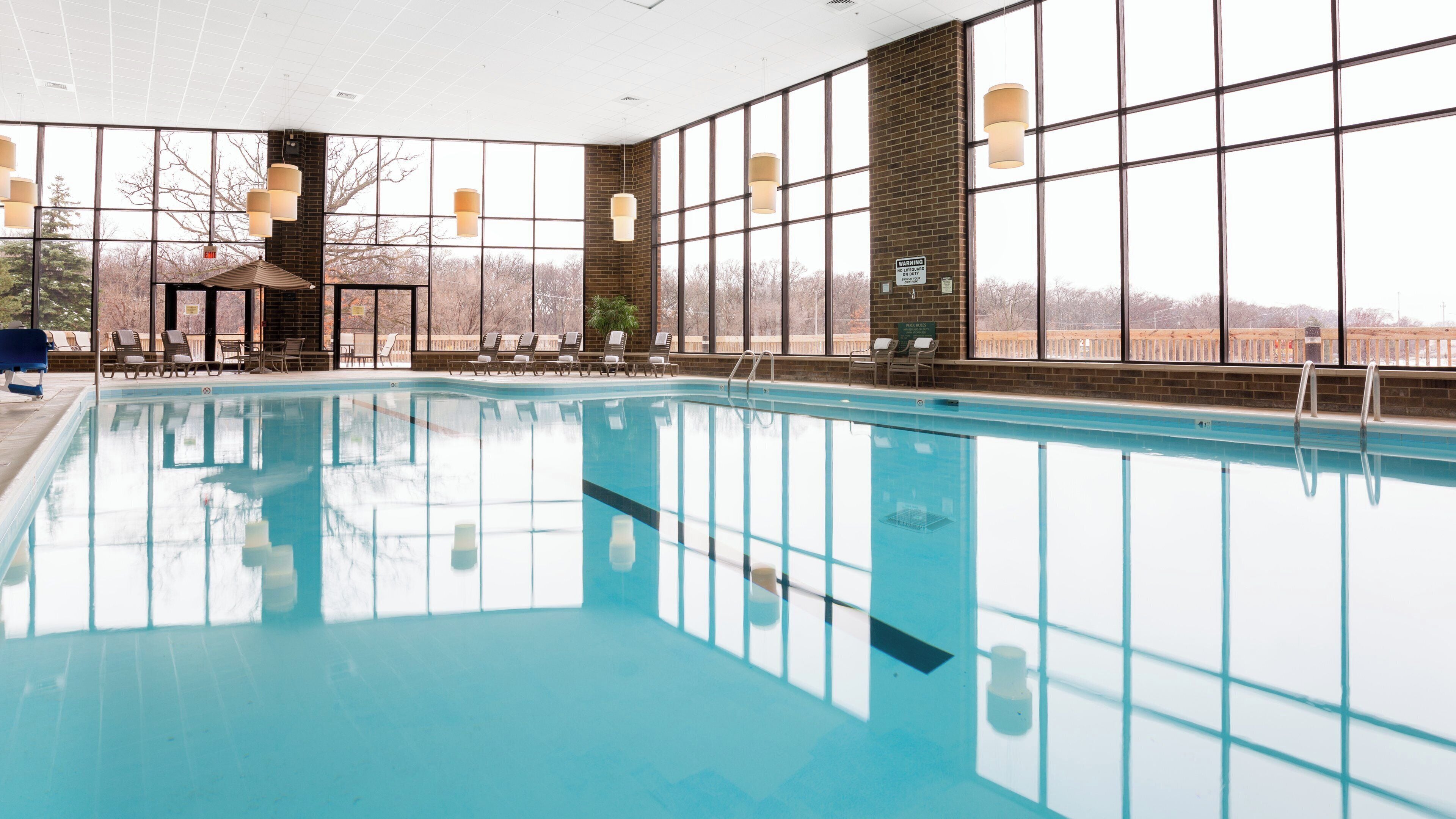 Una piscina techada, sillones reclinables de piscina