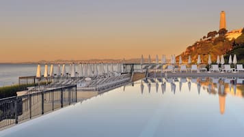 Una piscina techada, una piscina al aire libre, sombrillas