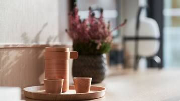Una mesa de madera con una pila de vasos y una taza pequeña sobre una bandeja.