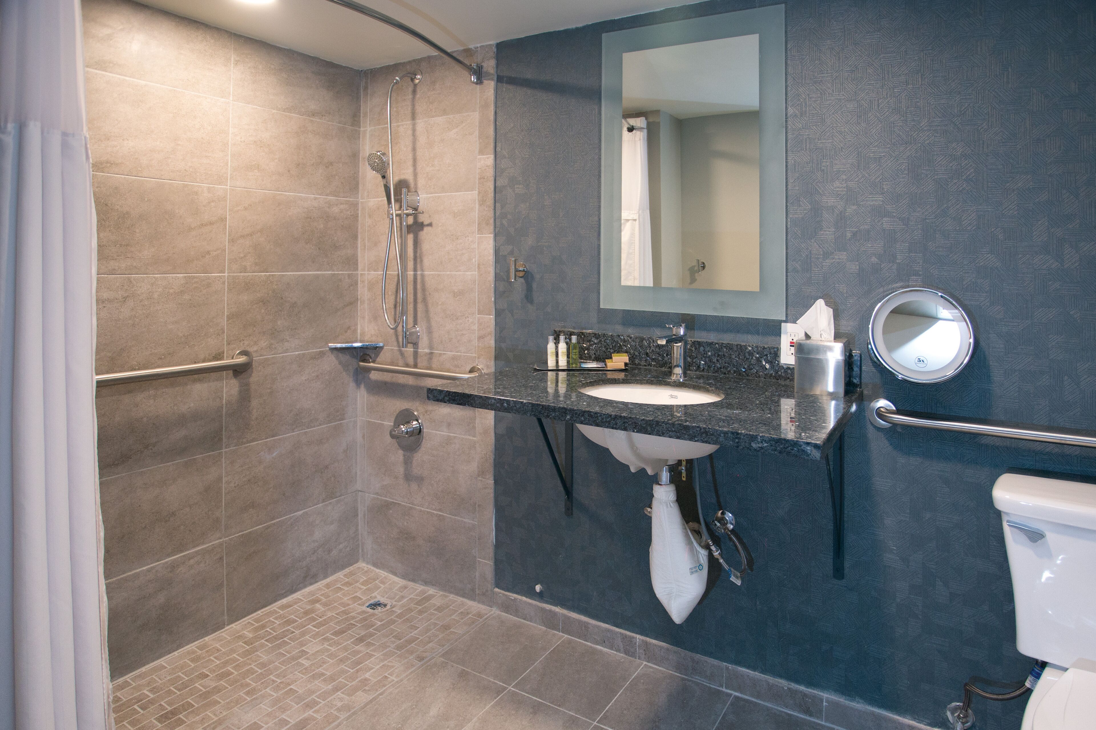 Un baño moderno con ducha, lavamanos e inodoro.