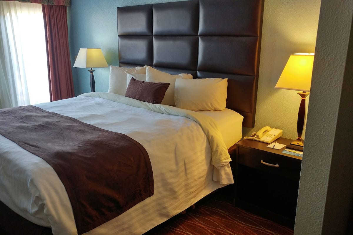 Escritorio, cortinas opacas, tabla de planchar con plancha