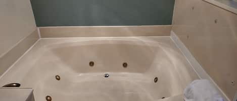 A bathtub with a white towel and a bottle of lotion.