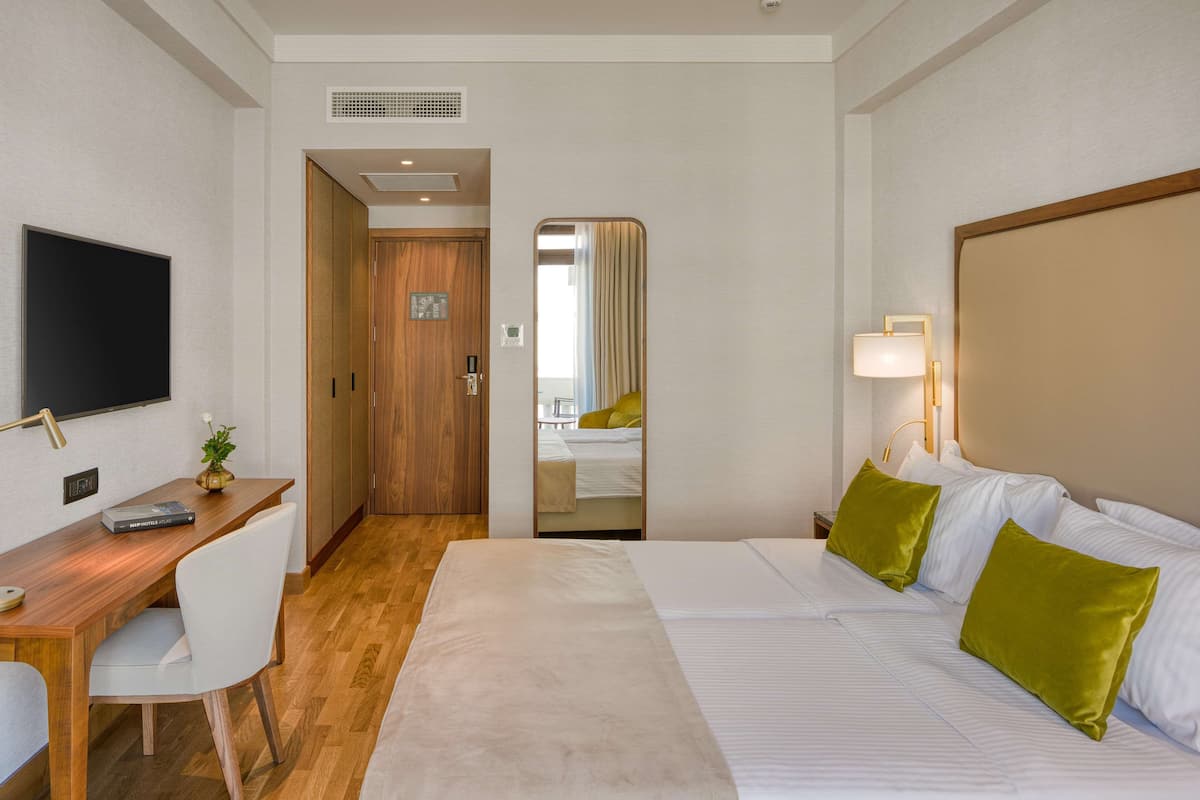 Premium kamer, 1 twee- of 2 eenpersoonsbedden, gedeeltelijk uitzicht op zee | Luxe beddengoed, een minibar, een kluis op de kamer, een bureau