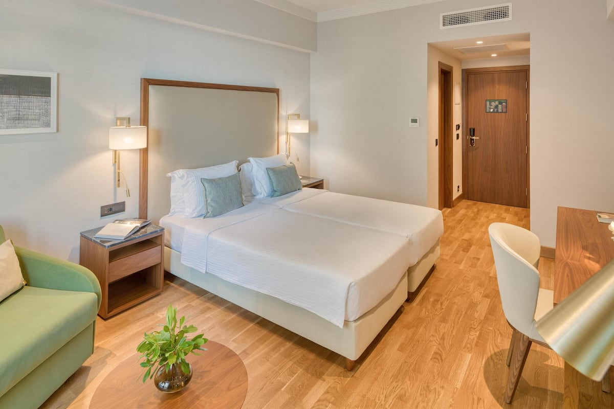 Superior driepersoonskamer | Luxe beddengoed, een minibar, een kluis op de kamer, een bureau