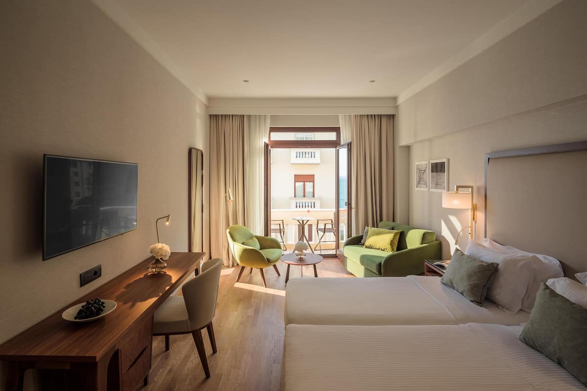 Premium driepersoonskamer, gedeeltelijk uitzicht op zee | Luxe beddengoed, een minibar, een kluis op de kamer, een bureau