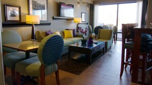 A modern living room with a sofa, chairs, a coffee table, and a TV mounted on the wall. - Hampton Inn Winchester-University/Mall Area (Winchester)