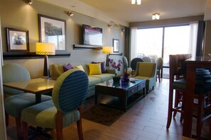 Relax in a cozy seating area with a sofa, armchairs, and dining table.