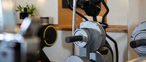 A gym with exercise equipment, including a stationary bike and a weight bench.
