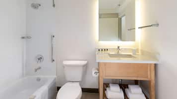 A modern bathroom with a bathtub, toilet, and vanity.