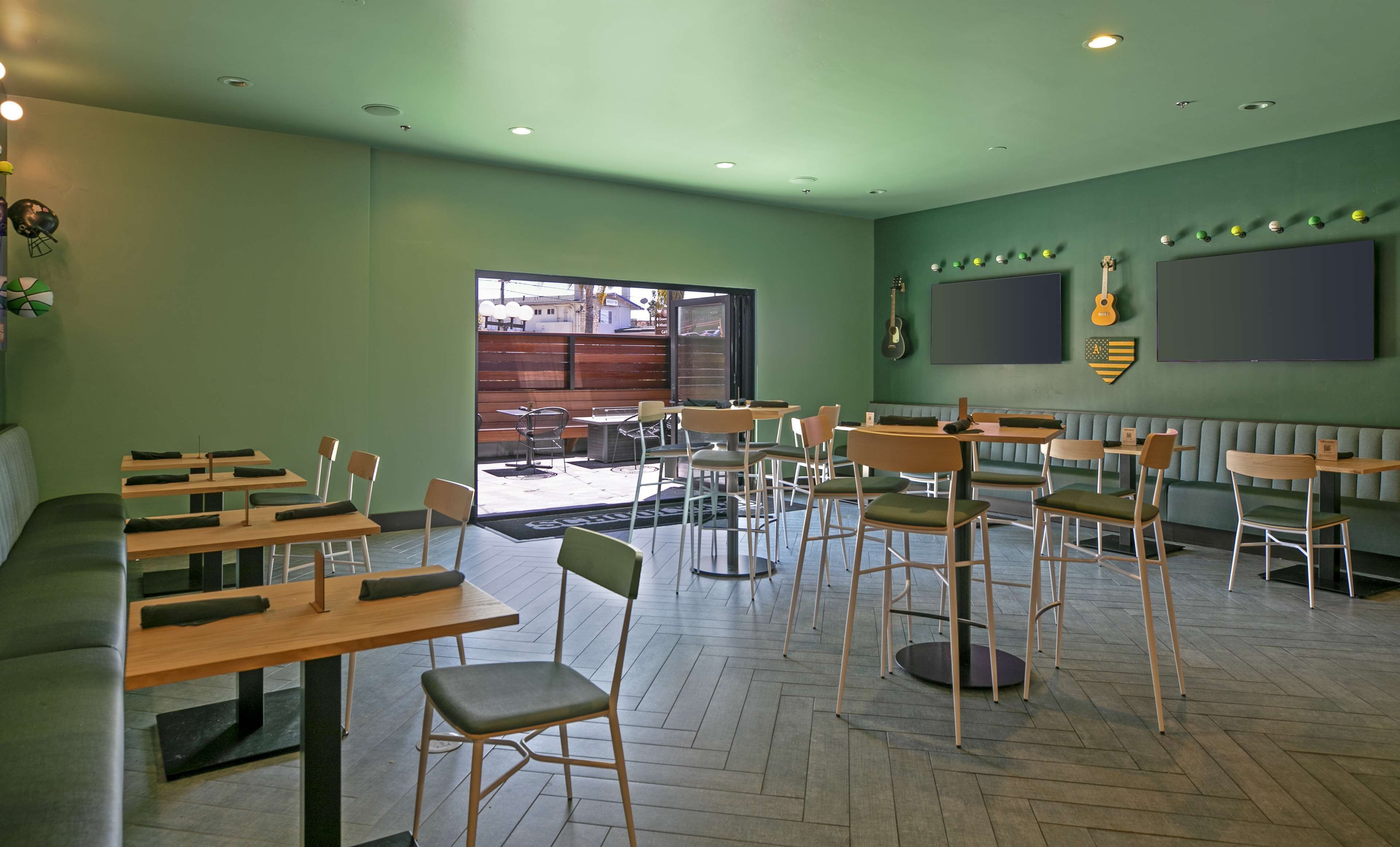 Een restaurant met meerdere tafels en stoelen, een groot raam en een podium.
