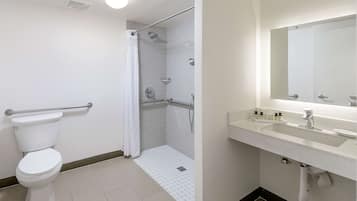 A bathroom with a toilet, shower, and sink.