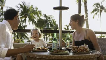 A dining table with plates of food, a bottle, and a decorative metal piece.