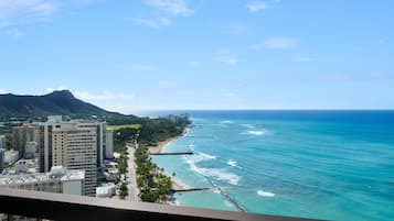 A coastal cityscape with high-rise buildings, a beach, and a mountain in the background.