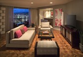 A modern living room with a sofa, armchairs, a coffee table, and a TV.