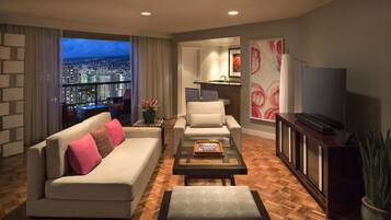 Una sala de estar moderna con sofá, sillones, una mesita de centro y televisor.