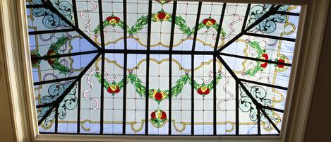 A stained glass window with floral patterns and a geometric design.