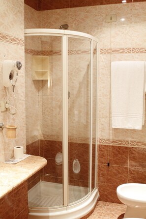 A bathroom with a glass-enclosed shower, a toilet, and a towel rack. - Pace Helvezia (Rome)