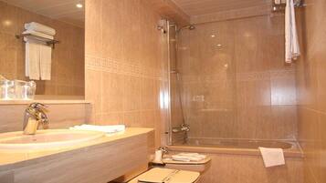 A bathroom with a sink, mirror, shower, and bathtub.