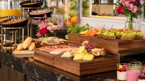 A buffet with various food items, including fruits, cheeses, and meats, arranged on a wooden counter. - The Davenport (Dublin)
