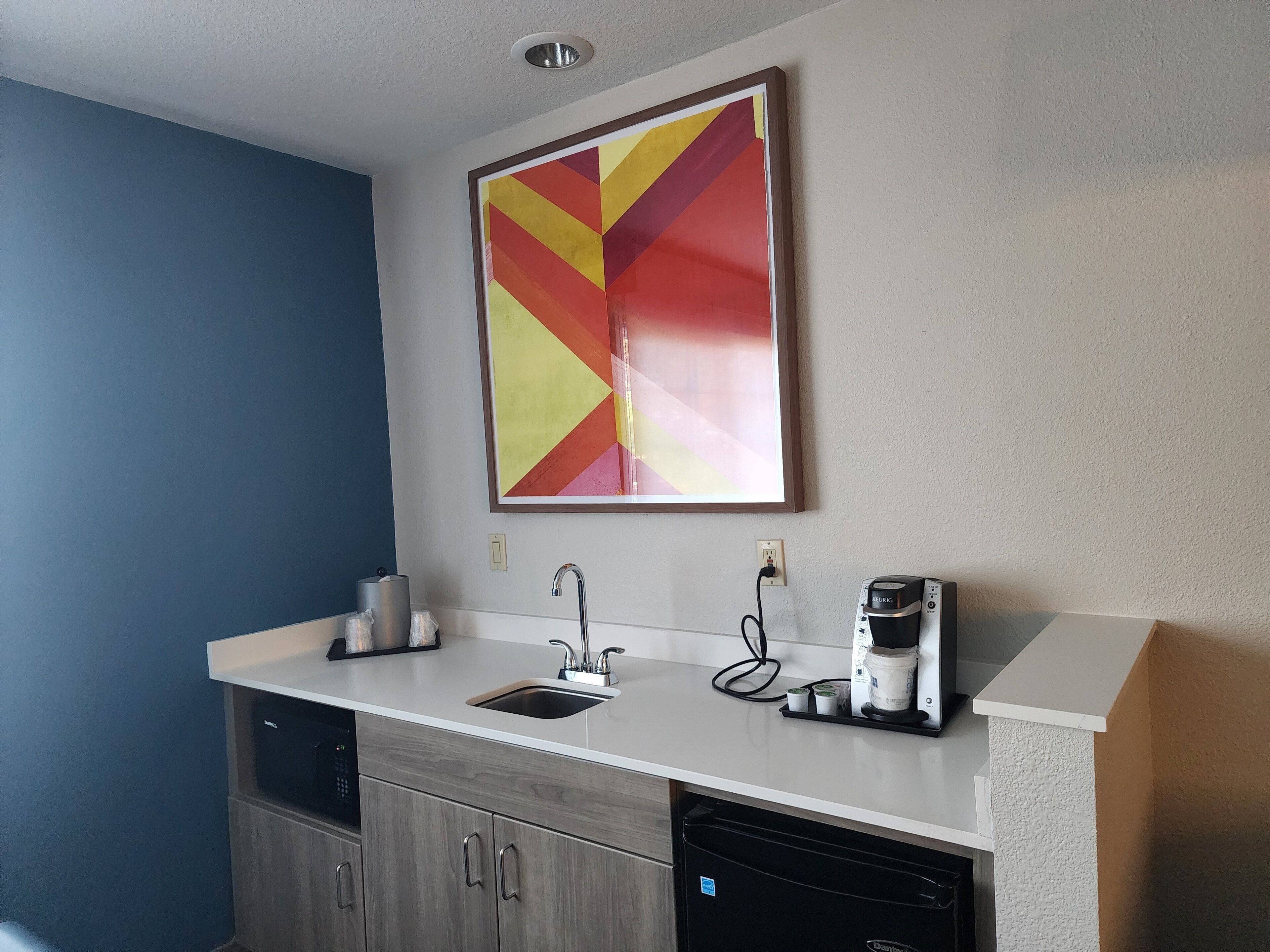 A modern kitchen with a built-in dishwasher, a coffee maker, and a wall-mounted power outlet.