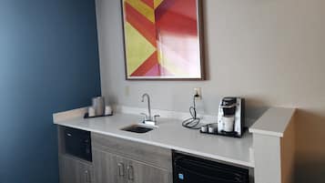 A modern kitchen with a built-in dishwasher, a coffee maker, and a wall-mounted power outlet.