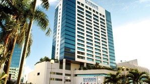 A tall hotel building with a modern glass facade, named "Riverside Majestic."