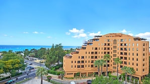 A multi-story hotel with balconies, located near a coastal area with visible ocean and palm trees. - Dom Pedro Marina (Loulé)
